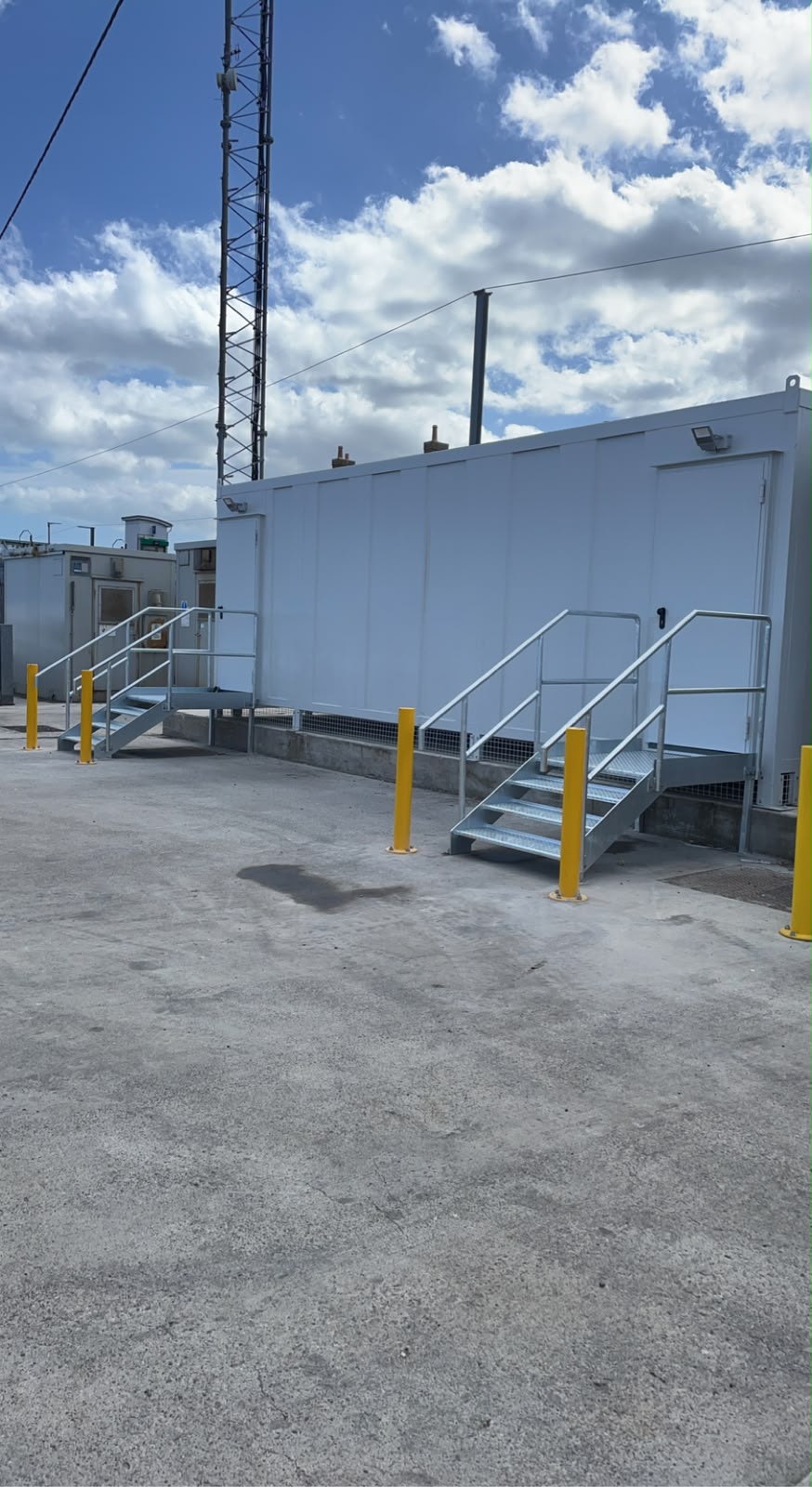 Galvanised access stairs and landing serving the entrance to a modular building