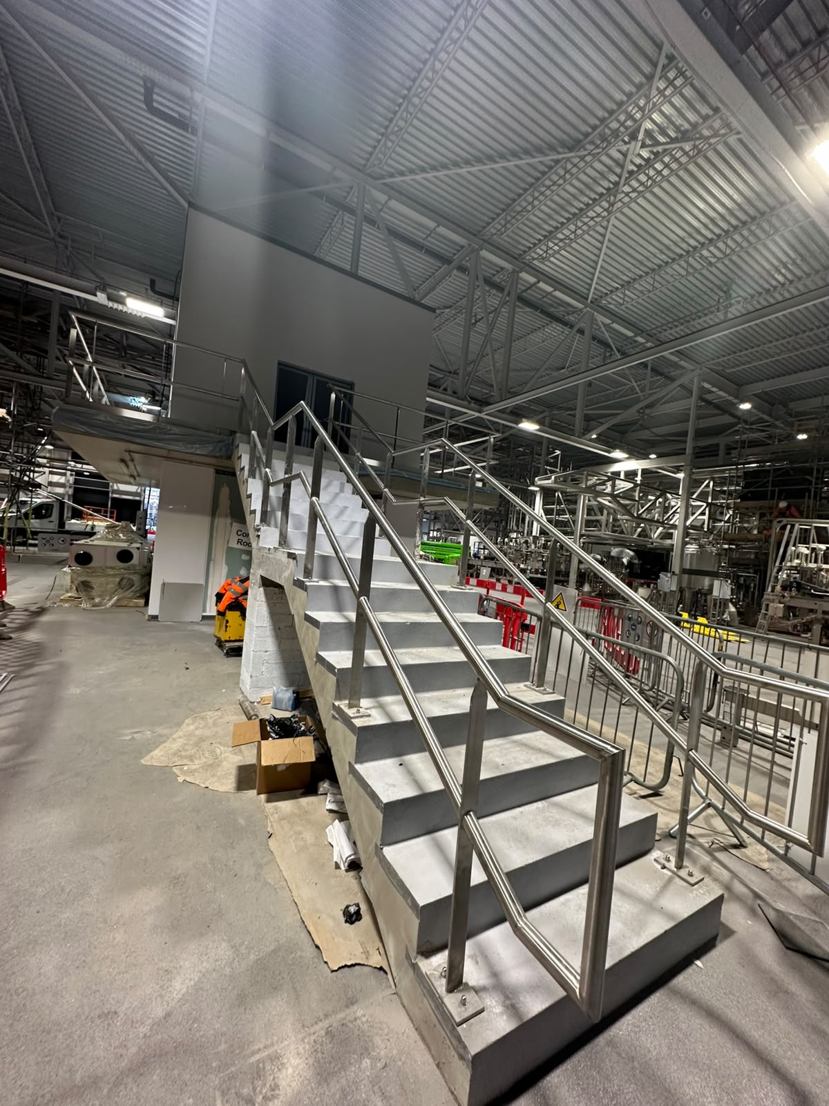 Stainless steel handrails to both sides of a commercial staircase