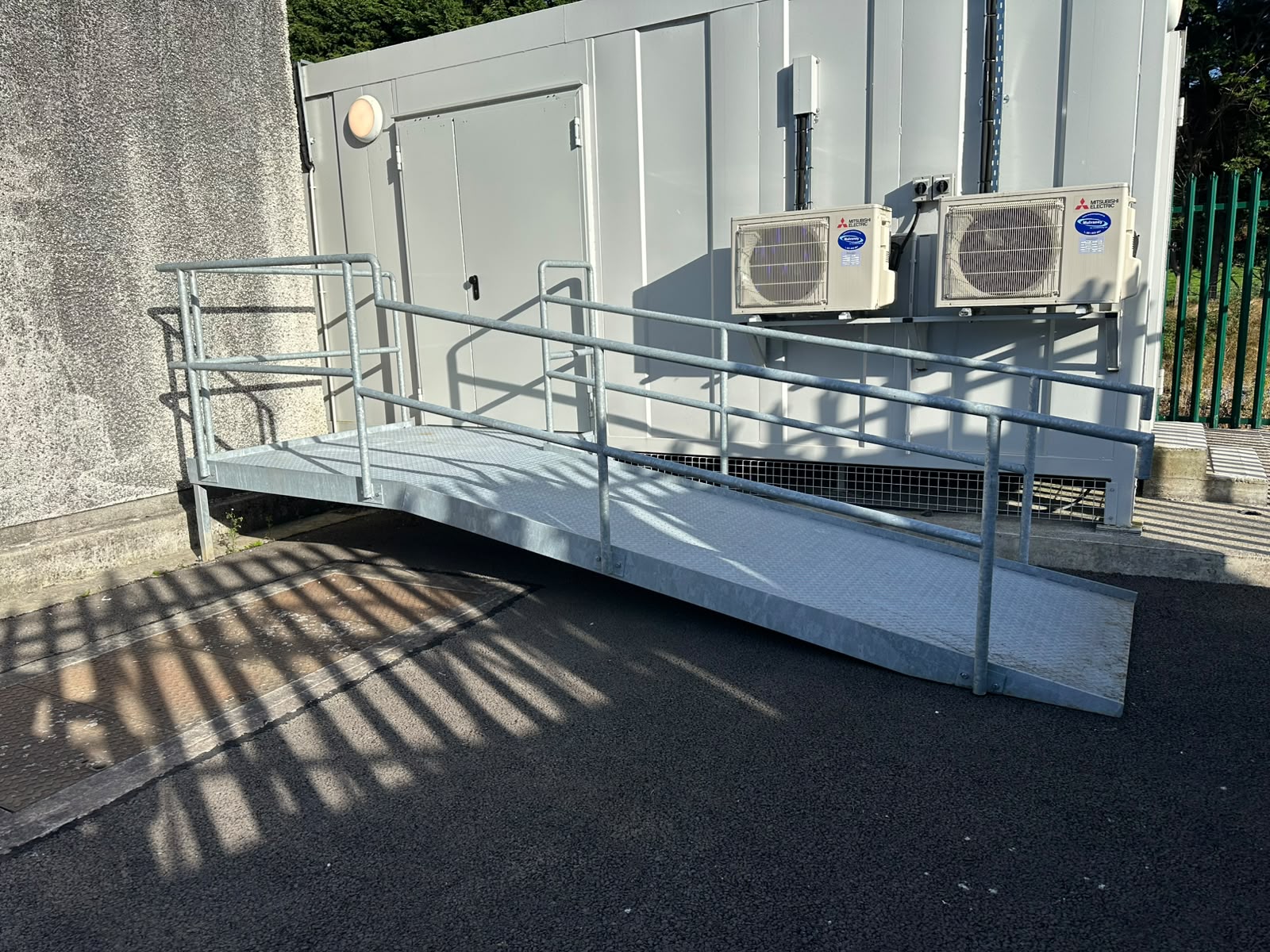 Galvanised steel access ramp with handrails to both sides