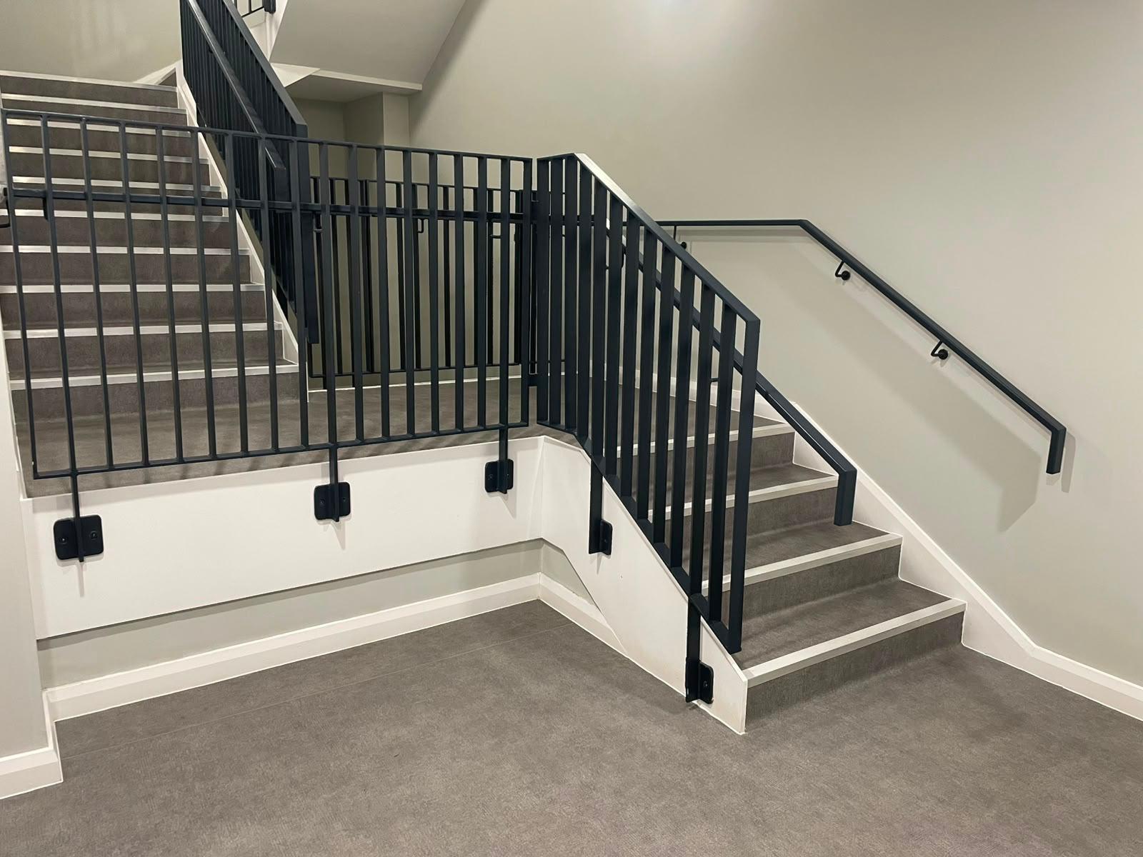 Finished commercial stair balustrade with vertical bar infill and steel handrail