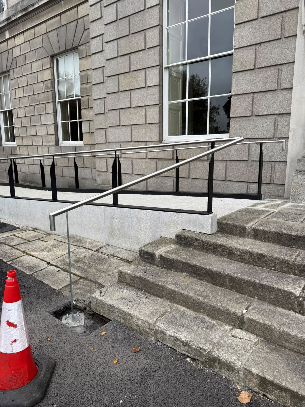 Polished stainless steel handrail at the entrance steps of a heritage building
