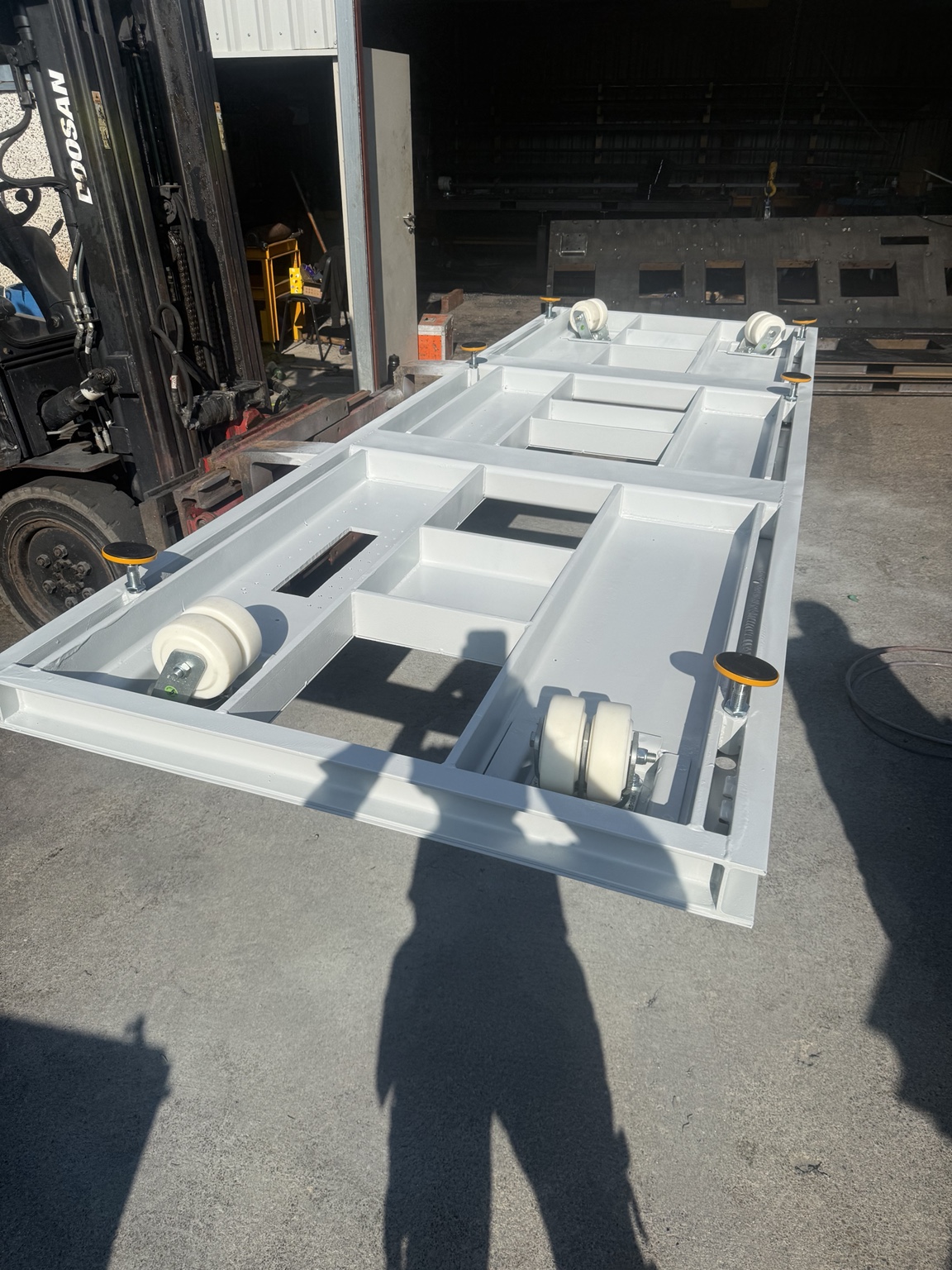 Structural steel skid framework with integrated support and transport assemblies in the workshop