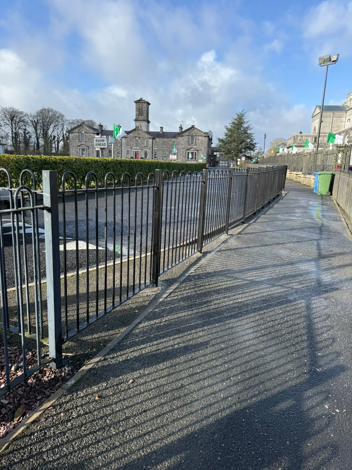 Painted steel pedestrian railings along a town centre footpath
