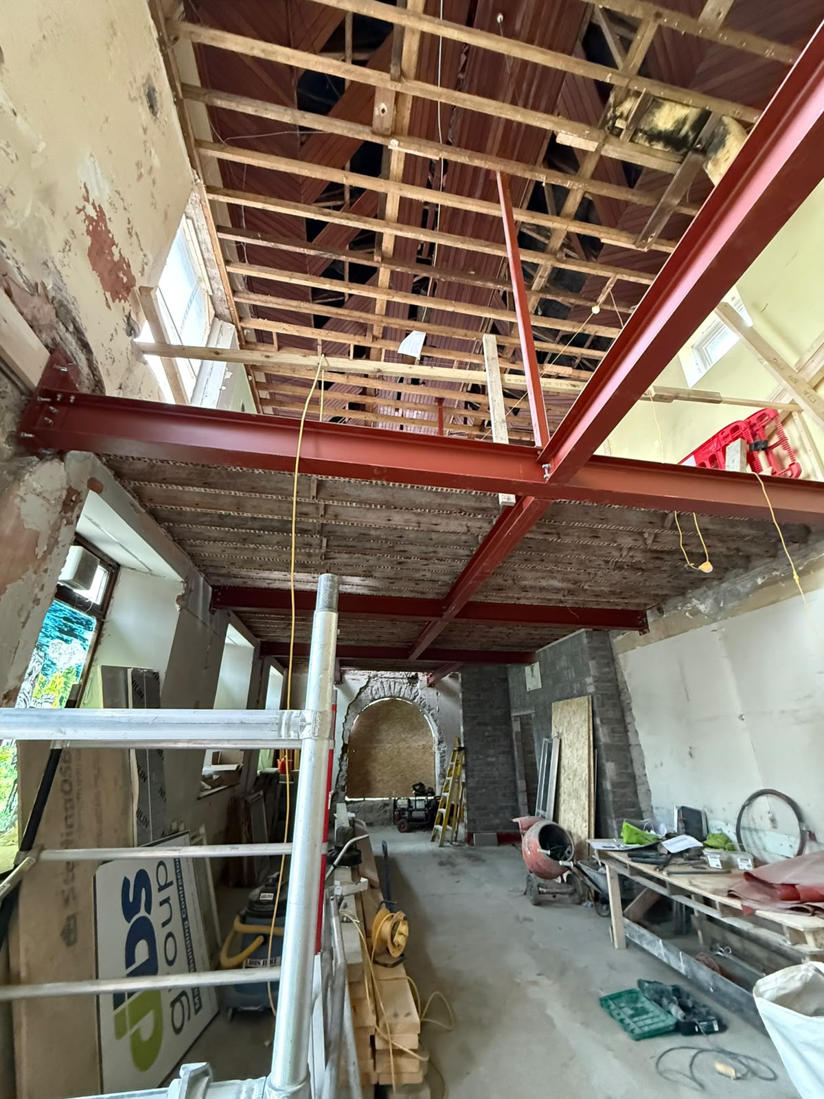 Red oxide painted steel beams installed at ceiling and roof level installed within an existing building
